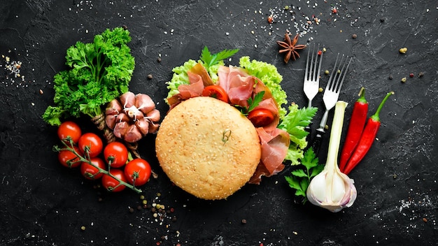 Burger au prosciutto sur fond de bois ancien Petit-déjeuner Vue de dessus Espace libre pour votre texte