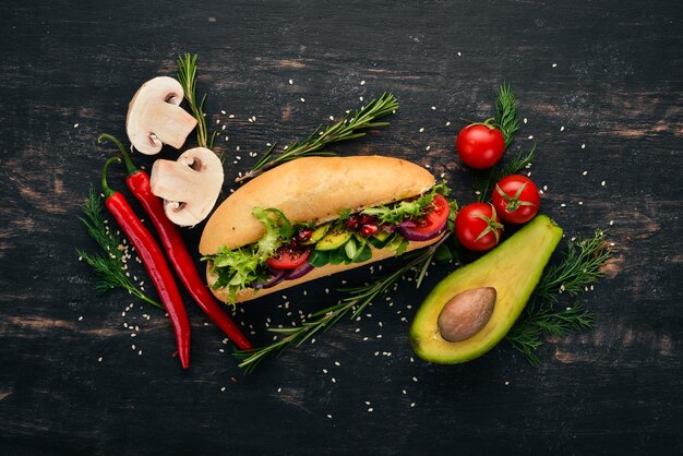 Burger avocat sandwich tomates cerises et feuilles de laitue Sur un fond en bois Vue de dessus Espace de copie