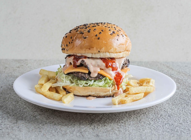 Burger de boeuf classique avec frites servi dans un plat isolé sur fond gris vue latérale de la restauration rapide