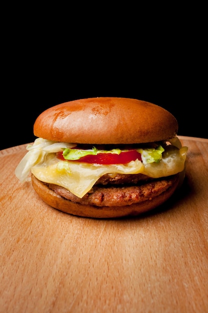 Burger de boeuf fait maison sur un fond en bois Burger savoureux frais avec des frites sur une table en bois