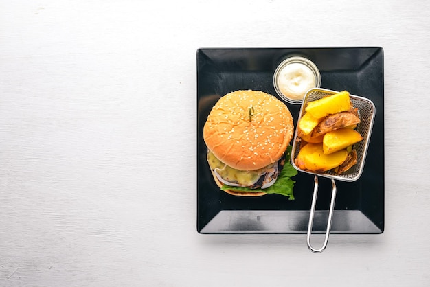Photo burger de boeuf friture de pommes de terre sur un fond en bois vue de dessus espace libre pour le texte