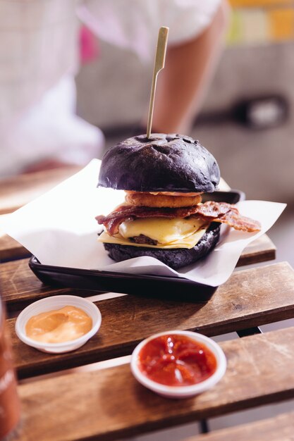 Photo burger de boeuf avec un pain noir avec du fromage