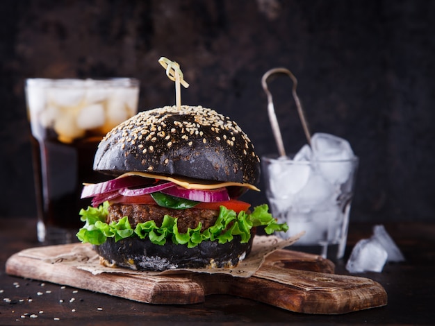 Burger de boeuf avec un petit pain noir, avec de la laitue et de la mayonnaise