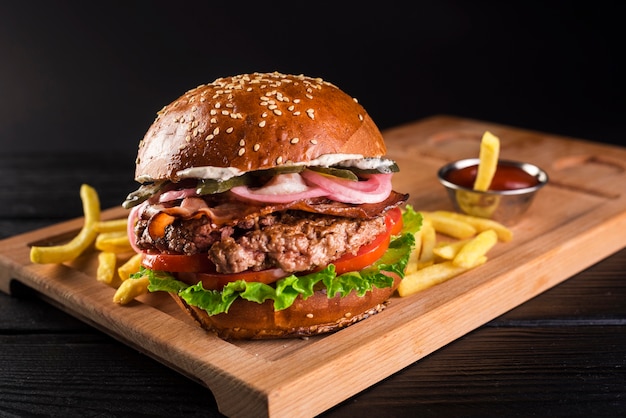 Burger de boeuf sur une planche de bois avec des frites