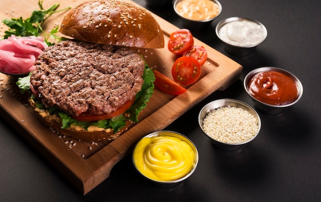 Photo burger de boeuf avec des sauces prêtes à servir