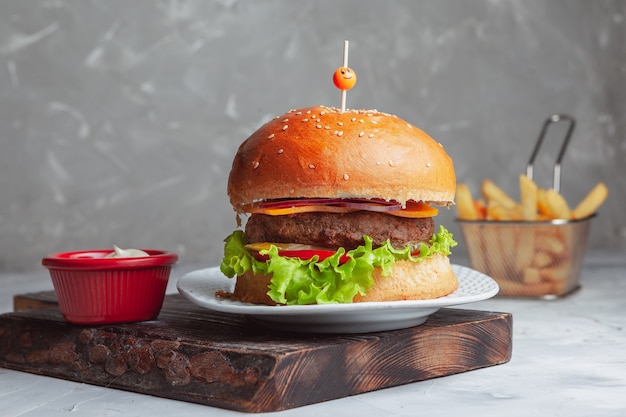 Photo burger de boeuf viande laitue tomate fromage frites vue latérale