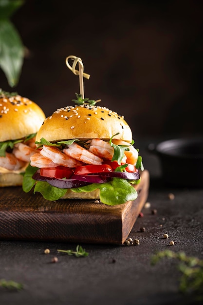 Burger délicieux aux crevettes sur une planche de bois