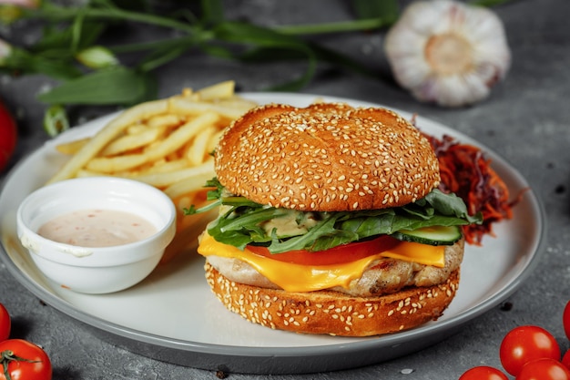 Burger de dinde sur un petit pain avec fromage, laitue, tomates et concombre frais.