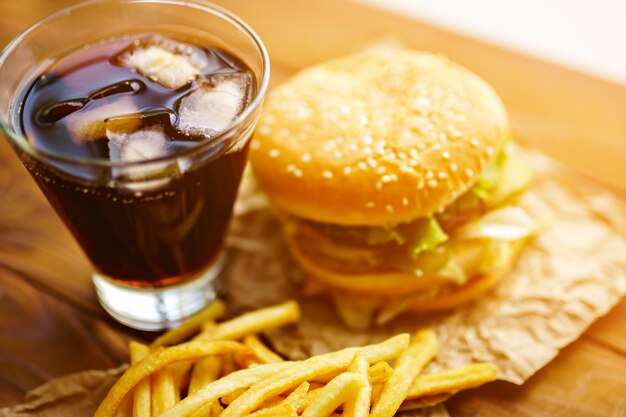 Burger sur du papier kraft avec des frites et du soda