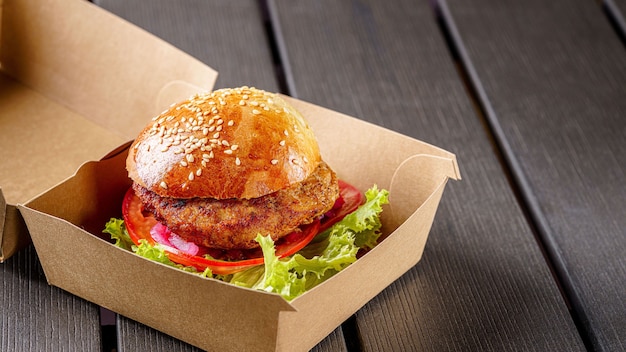 Burger d'escalope de viande dans une boîte en papier