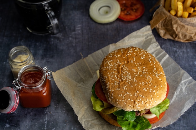 Burger fait à la main avec des frites avec du ketchup et un chiffon rouge