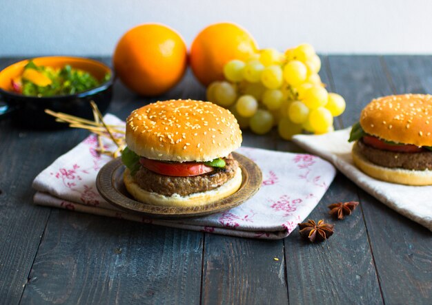 Burger fait maison avec des légumes et de la viande de boeuf sur une table en bois