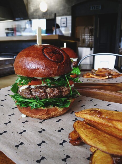 Photo burger fast food burger délicieux avec des bandes de bœuf frit laitue de tomate et oignon pain de farine de blé blanc croustillant avec des graines de sésame thème alimentaire