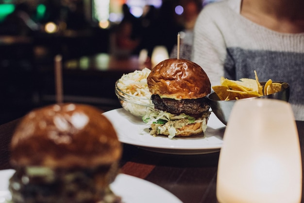 Photo burger fast food burger délicieux avec des bandes de bœuf frit laitue de tomate et oignon pain de farine de blé blanc croustillant avec des graines de sésame thème alimentaire