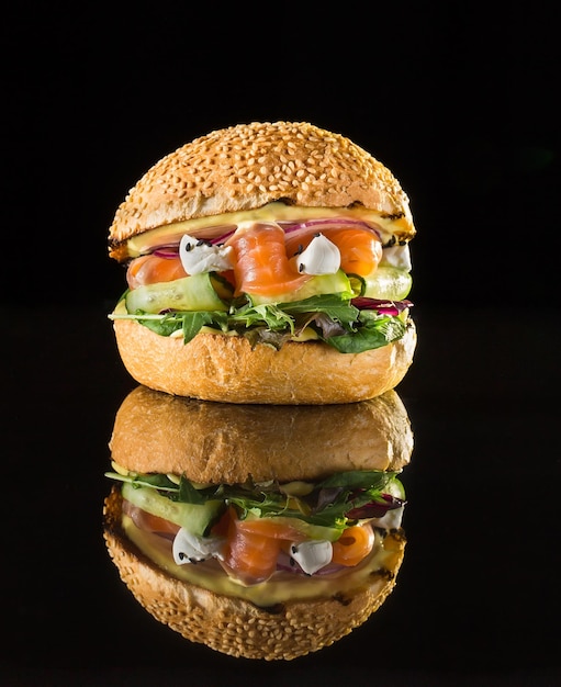 Burger frais avec des morceaux de saumon et de légumes