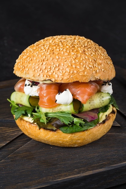 Burger frais avec des morceaux de saumon et de légumes