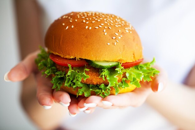 Burger frais et savoureux avec salade française de boeuf et tomate sur plaque jaune