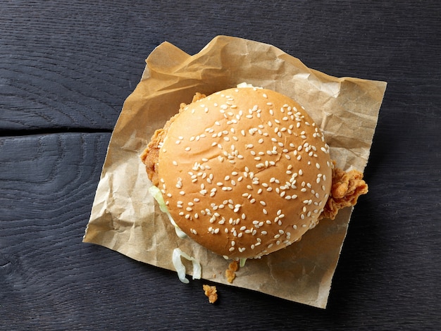 Burger frais et savoureux sur une table en bois noir, vue de dessus