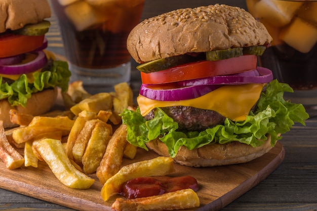 Burger, hamburger avec frites et légumes frais.