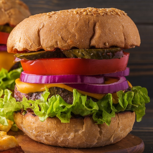 Burger, hamburger avec frites et légumes frais.