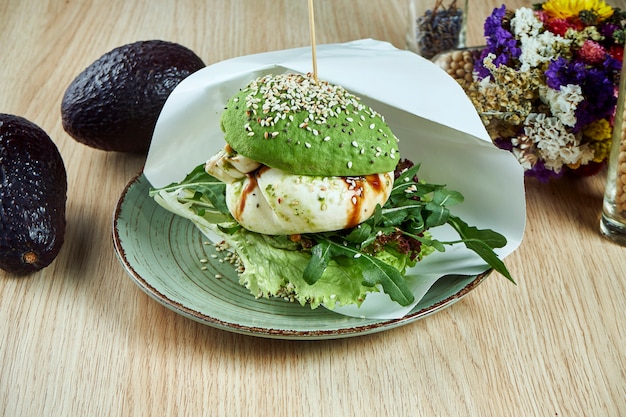 Photo un burger inhabituel à base de moitiés d'avocat, comme des petits pains avec du fromage burrata et de la ruccola. vue. nourriture saine et verte. vegan