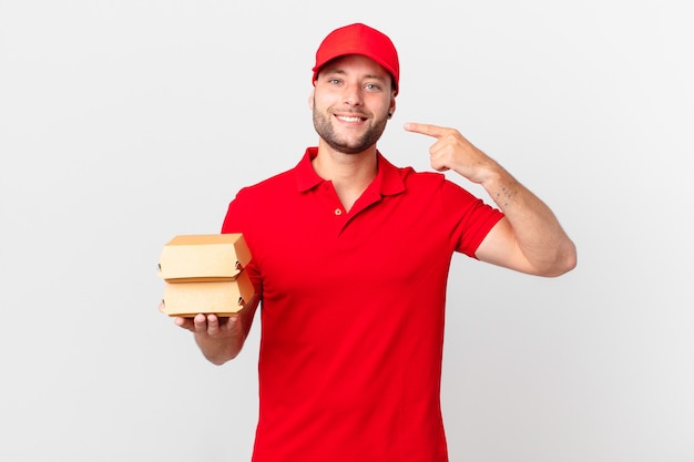 Burger livre un homme souriant avec confiance, pointant vers son propre large sourire