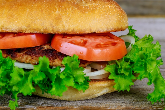 Burger maison fraîche sur une petite planche à découper en bois Image carrée avec mise au point sélective