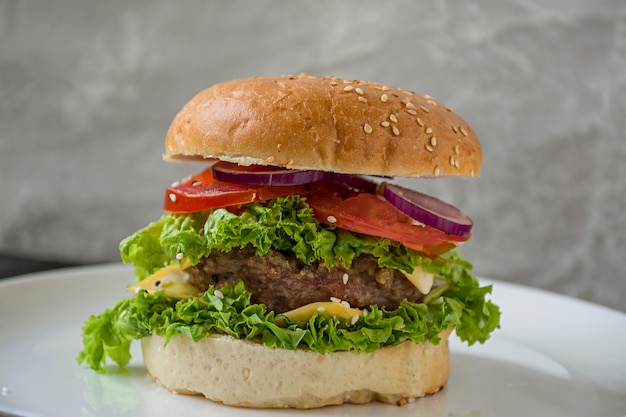 Burger maison frais sur une assiette blanche.