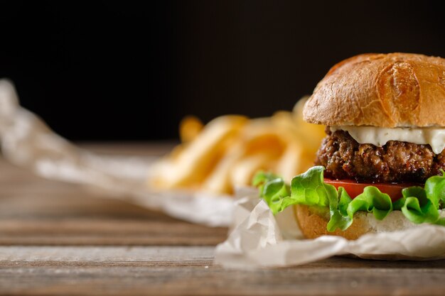 Burger maison avec frites sur table en bois