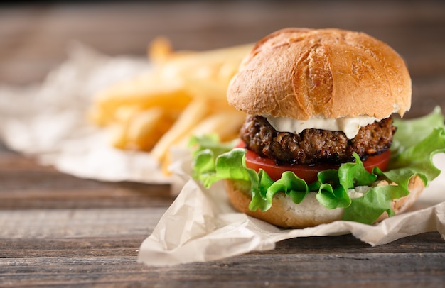 Burger maison avec frites sur table en bois