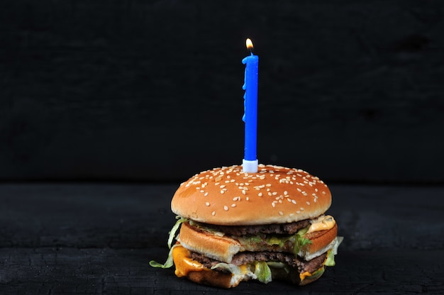 Burger mordu avec une bougie à feu