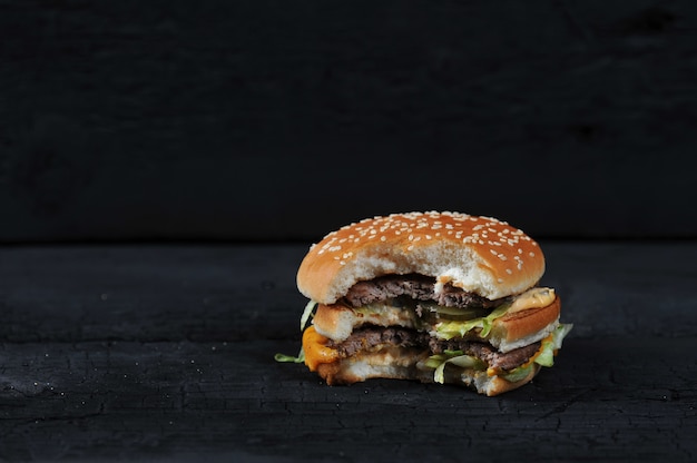 Burger mordu sur une sombre rustique