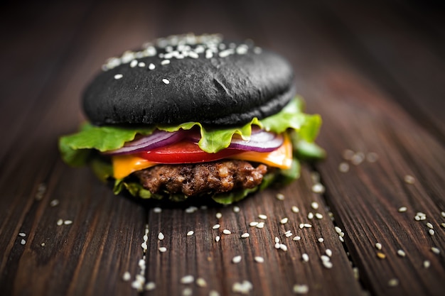 Burger noir fait maison avec du fromage. Cheeseburger avec pain noir