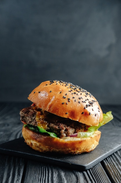 Photo burger sur planche de bois sombre