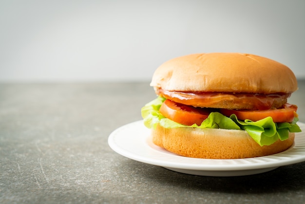 burger de poulet avec sauce sur plaque blanche