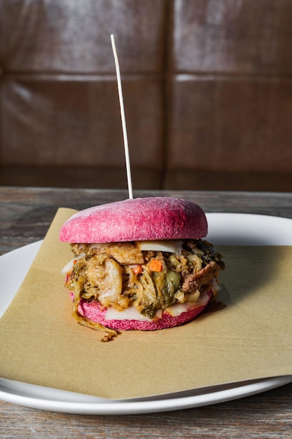 Burger rose avec cassuola italienne sur une table dans un restaurant un plat traditionnel d'une manière moderne