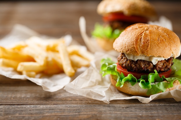 Burger savoureux fait maison et frites sur table en bois