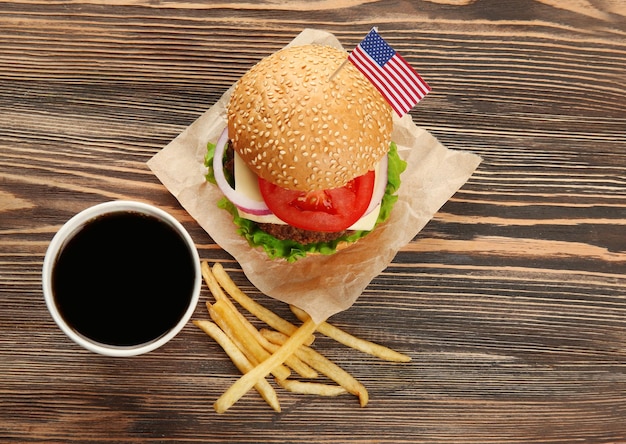 Burger savoureux avec frites de coke et drapeau américain sur la table