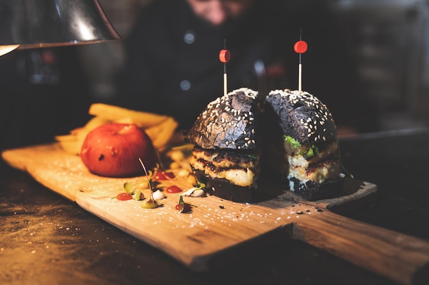 Burger de seiche et de calmar sur une plaque de bois.