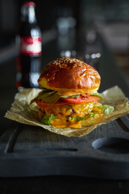 Burger servi sur planche de bois. Orientation portrait