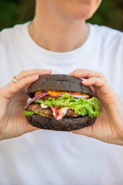 Burger végétarien et main de femme avec Vegan avec un morceau sans gluten avec graines de lin et jus