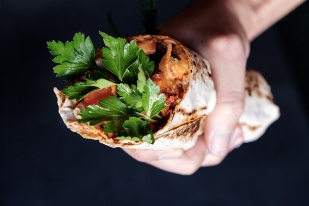 Burger végétarien de patates douces au tofu, tenu dans les mains.