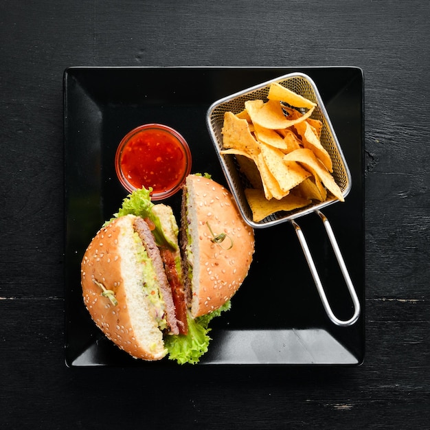 Burger avec viande et collations nachos Dans l'assiette Vue de dessus Espace libre pour votre texte Style rustique