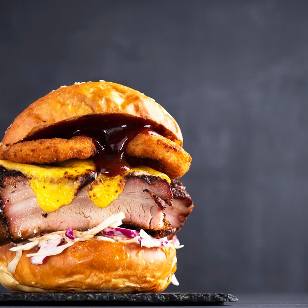 Burger de viande juteuse avec côtes de porc barbecue rondelles d'oignon fromage chou et laitue Restauration rapide