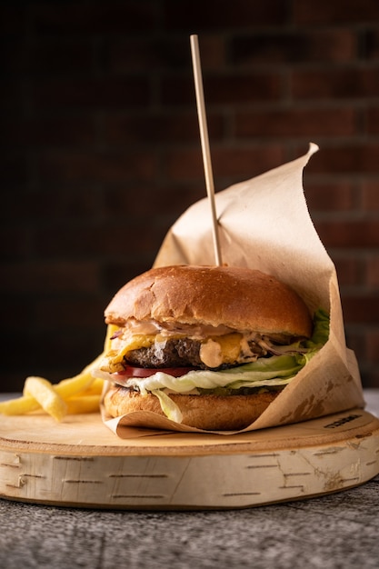 Burger de viande juteuse avec légumes frais et épices petit pain parfumé doux et sauces naturelles vue latérale sur...