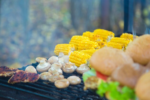 Burgers et maïs cuits à l'extérieur sur grill