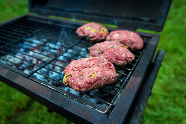 Burgers maison sur le gril. Escalopes de viande crue au piment