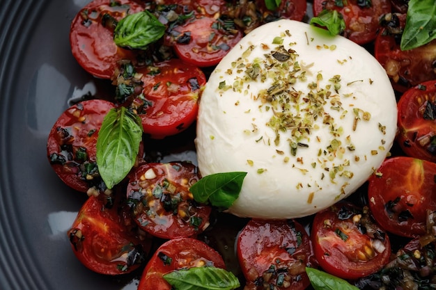 Burrata aux tomates cerises cuites au four et épices sur une assiette