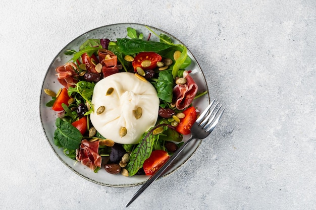 Burrata Fromage frais italien à base de crème et de lait de bufflonne ou de vache Salade de Burrata avec tomates et mélange de salade Concept d'alimentation saine Salade diététique Keto