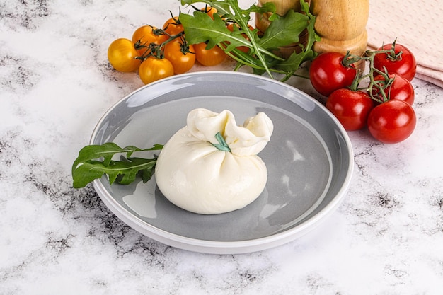 Burrata traditionnelle italienne crémeuse servie à la tomate et à la roquette